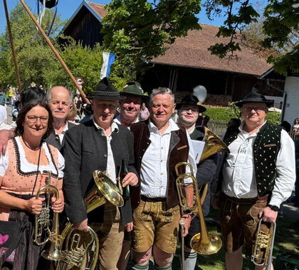 Pfatterer Buam posieren vor dem Maibaum, der gerade aufgestellt wird.