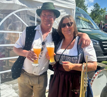Gerald Lugauer und Heike Hofer prosten sich fröhlich mit Weißbiergläsern zu.